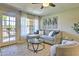 Bright living room showcases a cozy gray sectional, large window with sheer curtains, and access to a private balcony at 5950 N 78Th St # 102, Scottsdale, AZ 85250