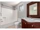 Bathroom features a vanity with a sink, a toilet, and a shower-tub combo with a white shower surround at 6033 S 19Th Pl, Phoenix, AZ 85042