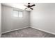 Neutral bedroom features a ceiling fan, a window with blinds, and soft gray carpet at 6033 S 19Th Pl, Phoenix, AZ 85042