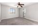 Carpeted bedroom featuring a window and a doorway, offering ample natural light and access to other rooms at 6033 S 19Th Pl, Phoenix, AZ 85042