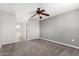 Carpeted bedroom with a ceiling fan and neutral paint, showcasing a clean and simple aesthetic at 6033 S 19Th Pl, Phoenix, AZ 85042