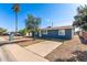 Well-maintained single-story home featuring a spacious driveway, mature landscaping, and a classic blue exterior at 6033 S 19Th Pl, Phoenix, AZ 85042
