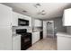 Modern kitchen featuring white cabinets, black appliances, and a stylish view into the living room at 6033 S 19Th Pl, Phoenix, AZ 85042