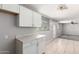 Bright kitchen features white cabinets, countertops, and tile flooring throughout the space at 6033 S 19Th Pl, Phoenix, AZ 85042
