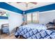 Charming bedroom with a wooden bed, window and blue color scheme at 6528 S 258Th Dr, Buckeye, AZ 85326
