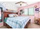 Colorful bedroom with decorative wall accents, a window, and a wooden bed frame at 6528 S 258Th Dr, Buckeye, AZ 85326