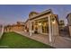 View of covered patio and fenced-in backyard with low-maintenance turf and stucco exterior at 668 S Catalina St, Gilbert, AZ 85233