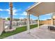 Spacious backyard features a covered patio, waterfront views, privacy wall, and manicured artificial turf at 668 S Catalina St, Gilbert, AZ 85233