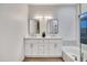 Bathroom featuring double sinks, a soaking tub, and modern fixtures for a luxurious experience at 668 S Catalina St, Gilbert, AZ 85233