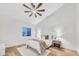 Bright bedroom featuring a ceiling fan, stylish nightstand, and a comfortable bed with a cozy throw blanket at 668 S Catalina St, Gilbert, AZ 85233