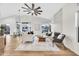 Bright living room featuring hardwood floors, a modern ceiling fan, fireplace, and an open floor plan at 668 S Catalina St, Gilbert, AZ 85233