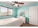 Bedroom features a ceiling fan, dresser and aqua walls at 6746 W Wethersfield Rd, Peoria, AZ 85381