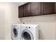Bright laundry room featuring a modern washer and dryer with overhead cabinetry at 6746 W Wethersfield Rd, Peoria, AZ 85381