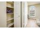 Linen closet showcasing organized storage with open shelving, complemented by the natural light from the nearby window at 6831 S Coral Gable Dr, Chandler, AZ 85249