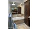 Elegant bathroom featuring a soaking tub, neutral tile, and ample cabinet space at 7272 E Gainey Ranch Rd # 121, Scottsdale, AZ 85258