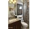 Modern bathroom featuring granite counters, framed mirror, tile shower with window, and low-flow toilet at 7272 E Gainey Ranch Rd # 121, Scottsdale, AZ 85258