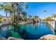 Scenic community lake view featuring pristine water and lush landscaping with mature palm trees on a sunny day at 7272 E Gainey Ranch Rd # 121, Scottsdale, AZ 85258