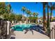 Community pool surrounded by palm trees and lounge chairs at 7272 E Gainey Ranch Rd # 121, Scottsdale, AZ 85258