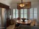 Kitchen featuring stainless steel appliances, eat-in table with shuttered windows and artwork at 7272 E Gainey Ranch Rd # 121, Scottsdale, AZ 85258