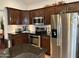 Modern kitchen with stainless steel appliances, wood cabinetry, and granite countertops at 7272 E Gainey Ranch Rd # 121, Scottsdale, AZ 85258