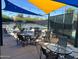Outdoor patio with plenty of seating and shade, overlooking tennis courts for social gatherings at 7272 E Gainey Ranch Rd # 121, Scottsdale, AZ 85258