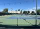 Well-maintained tennis courts surrounded by fencing and lush greenery in a community setting at 7272 E Gainey Ranch Rd # 121, Scottsdale, AZ 85258