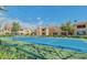 Community tennis court surrounded by mature trees and well-maintained landscaping at 7575 E Indian Bend Rd # 2002, Scottsdale, AZ 85250