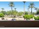 Balcony view overlooking lush landscaping, mature trees, and distant mountain views at 7575 E Indian Bend Rd # 2002, Scottsdale, AZ 85250