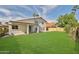 Back yard view of the home with a covered patio, lawn, and lush landscaping at 7633 W Kristal Way, Glendale, AZ 85308
