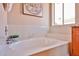 Comfortable bathroom features a tub with white tile surround and a sunny window at 7633 W Kristal Way, Glendale, AZ 85308