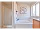 Clean bathroom features a tub with white tile surround and a glass enclosed shower at 7633 W Kristal Way, Glendale, AZ 85308
