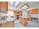 Bright kitchen featuring tile flooring, center island with white granite countertops, and wood cabinets at 7633 W Kristal Way, Glendale, AZ 85308