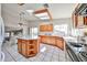 Eat-in kitchen with tile flooring, wood cabinets, center island, ceiling fan, and breakfast nook at 7633 W Kristal Way, Glendale, AZ 85308