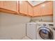 Spacious laundry room includes washer, dryer and storage cabinets at 7633 W Kristal Way, Glendale, AZ 85308
