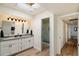 Modern bathroom with dual sinks, white cabinetry, skylight, and glass-enclosed shower at 9224 N 126Th St, Scottsdale, AZ 85259