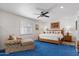 Cozy bedroom with a wooden bed frame, plush blue carpeting, and bright natural lighting at 9224 N 126Th St, Scottsdale, AZ 85259