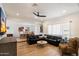 Spacious living room boasts a black leather sofa, ceiling fan, and hardwood flooring at 9224 N 126Th St, Scottsdale, AZ 85259