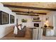 Comfortable living room with exposed beams, wood ceiling, a cozy fireplace, and neutral decor at 9224 N 126Th St, Scottsdale, AZ 85259