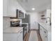 Open kitchen boasts stainless appliances, quartz counters, white cabinetry and wood look flooring at 948 S Alma School Rd # 13, Mesa, AZ 85210