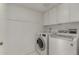 Laundry room with white washer and dryer units, storage cabinets and hanging rack at 9629 N 83Rd Way, Scottsdale, AZ 85258