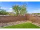 Well-maintained backyard featuring artificial grass, a retaining wall, and desert landscaping for easy maintenance at 16498 W Gary Way, Goodyear, AZ 85338