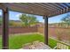 Charming covered patio with artificial grass and desert landscaping, perfect for enjoying the outdoors at 16498 W Gary Way, Goodyear, AZ 85338