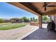 Spacious covered back patio featuring a built-in barbecue area, ceiling fan and brick pavers at 17451 W Hadley St, Goodyear, AZ 85338