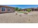 Backyard with low maintenance landscaping, outdoor fire pit and desert flora at 17451 W Hadley St, Goodyear, AZ 85338