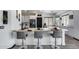 Bright kitchen with white cabinets, marble countertops, breakfast bar, and modern stainless steel appliances at 17451 W Hadley St, Goodyear, AZ 85338