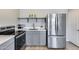 Modern kitchen includes stainless steel appliances, gray cabinets, quartz countertops, and stylish decor at 17451 W Hadley St, Goodyear, AZ 85338