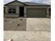 Charming single-story home featuring a two-car garage and low maintenance desert landscaping in the front yard at 2025 E Bucking Bronco Dr, San Tan Valley, AZ 85140