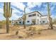 Two-story desert home with white stucco, flat roof, desert landscaping and mature cactus at 3215 N 83Rd St, Mesa, AZ 85207