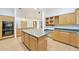 Kitchen with light-wood cabinets, black appliances, an island and adjacent eat-in area at 3215 N 83Rd St, Mesa, AZ 85207