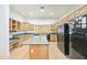 Bright kitchen featuring light wood cabinets, black appliances, and a central island at 3215 N 83Rd St, Mesa, AZ 85207